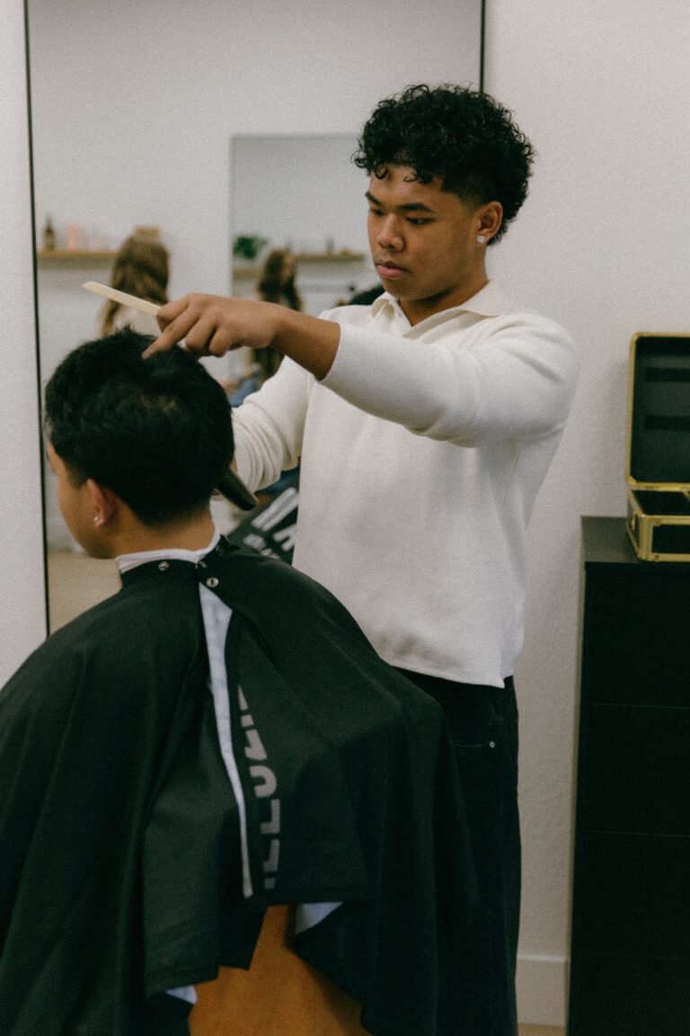 Jhyro cutting hair in a white long sleeve shirt
